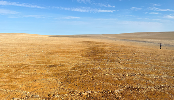 Photo of the southern area of the Tempest copper and zinc gossans looking north. The brown-red
rust-coloured gossans are indicative of potential base metal mineralization below surface and canbe
traced for over 4km along strike. Aston Bay CEO, Tom Ullrich, is seen at the right of the photo for scale.