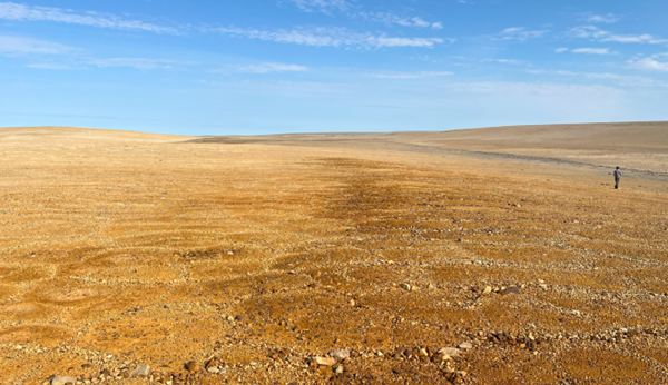 Figure 5: Photo of the Tempest copper and zinc gossans looking north. The brown-red rust-coloured gossans are indicative of potential base metal
mineralization below surface and can be traced for over 4km along strike. Aston Bay CEO, Tom Ullrich, is seen at the right of the photo for scale.